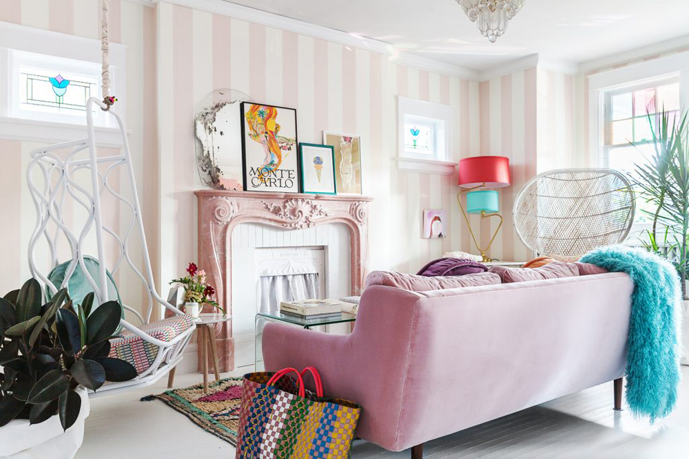 Pink living room with artwork on fireplace mantel