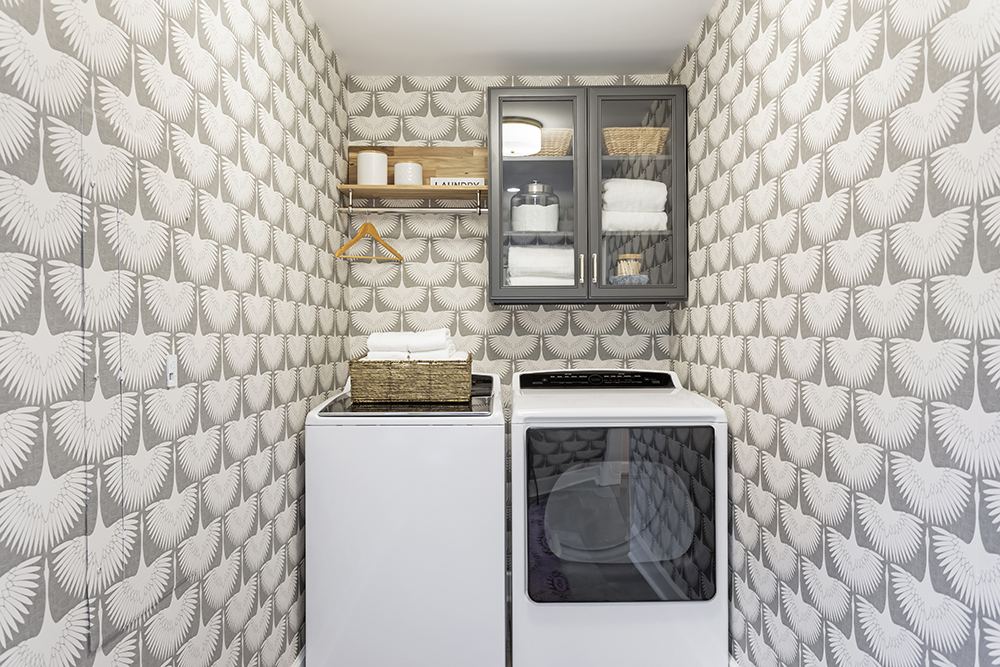 A laundry room with decorative wallpaper
