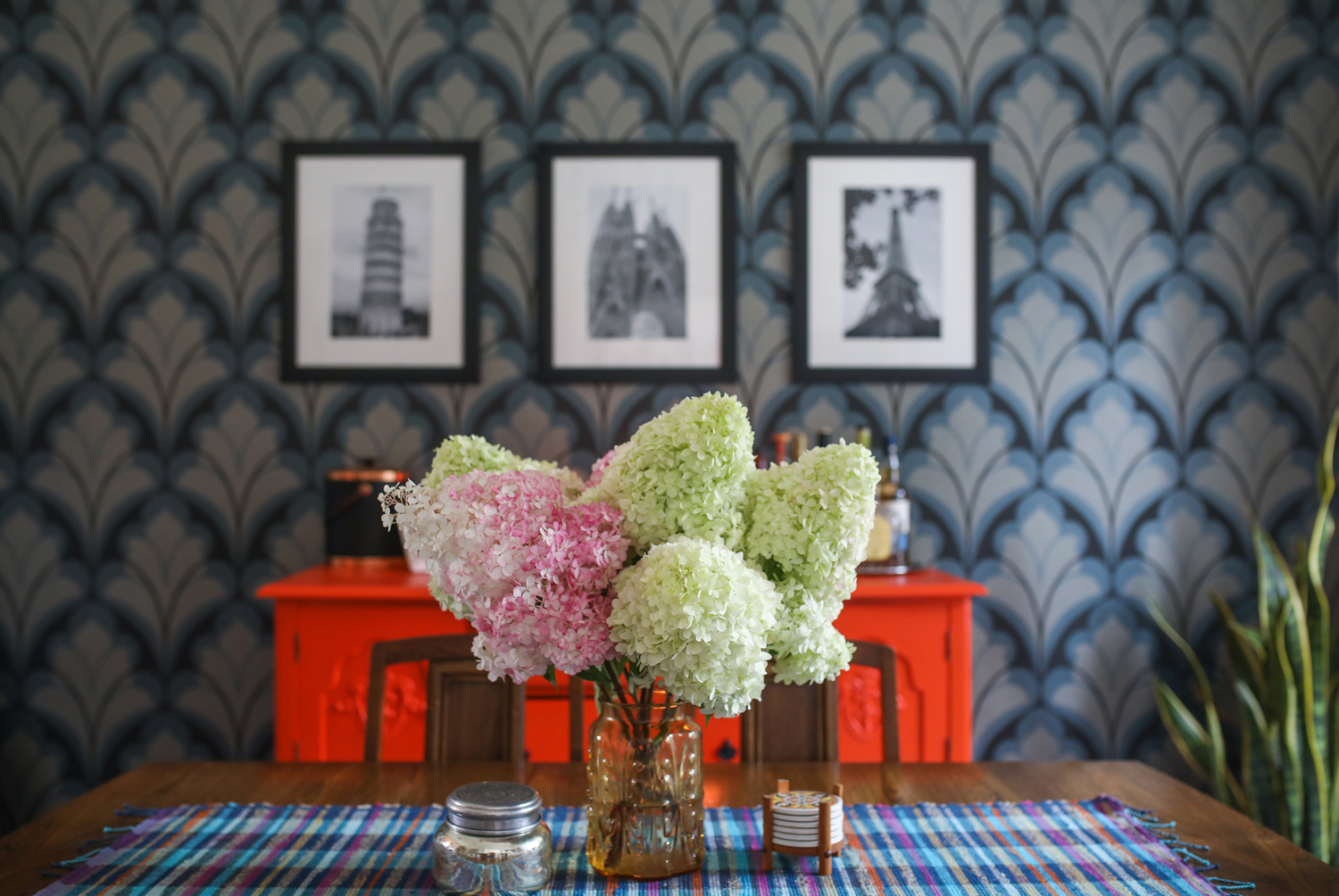 Dining room with patterned wallpaper and floral arrangement
