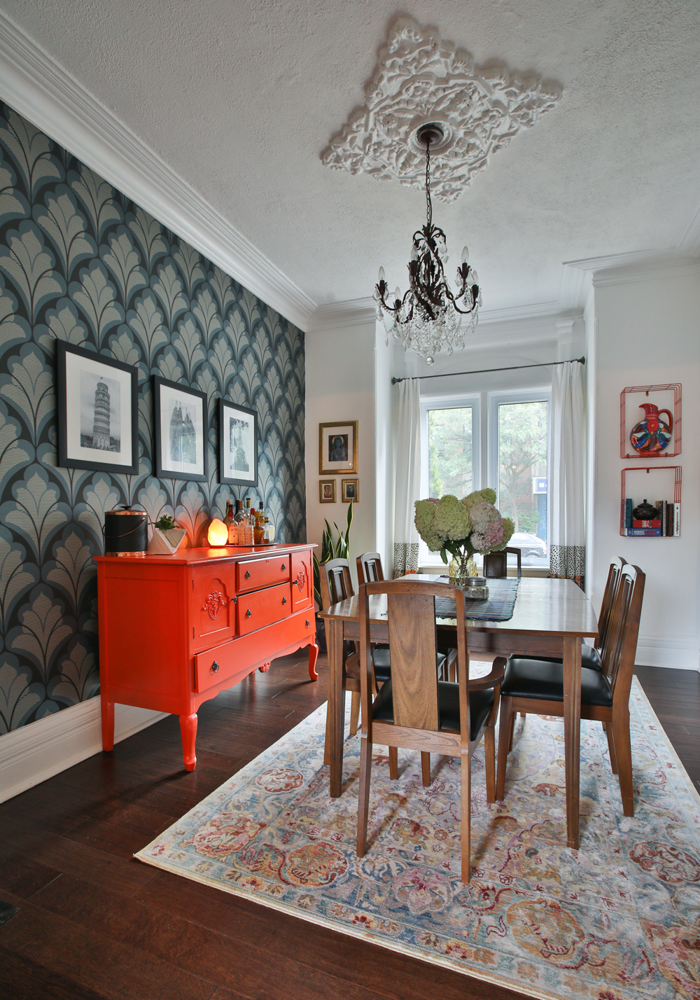 Dining room with orange sideboard and patterned wallpaper