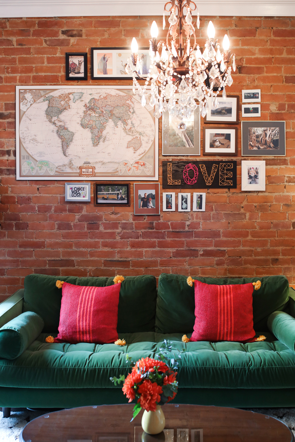 Exposed brick wall and green velvet couch