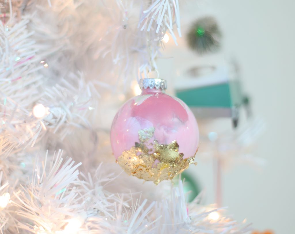 A painted ornament hanging in a christmas tree