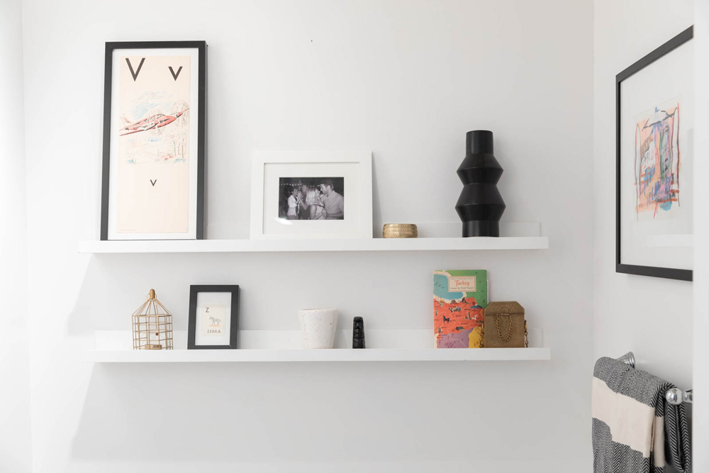 A gallery wall on floating shelves in the bathroom