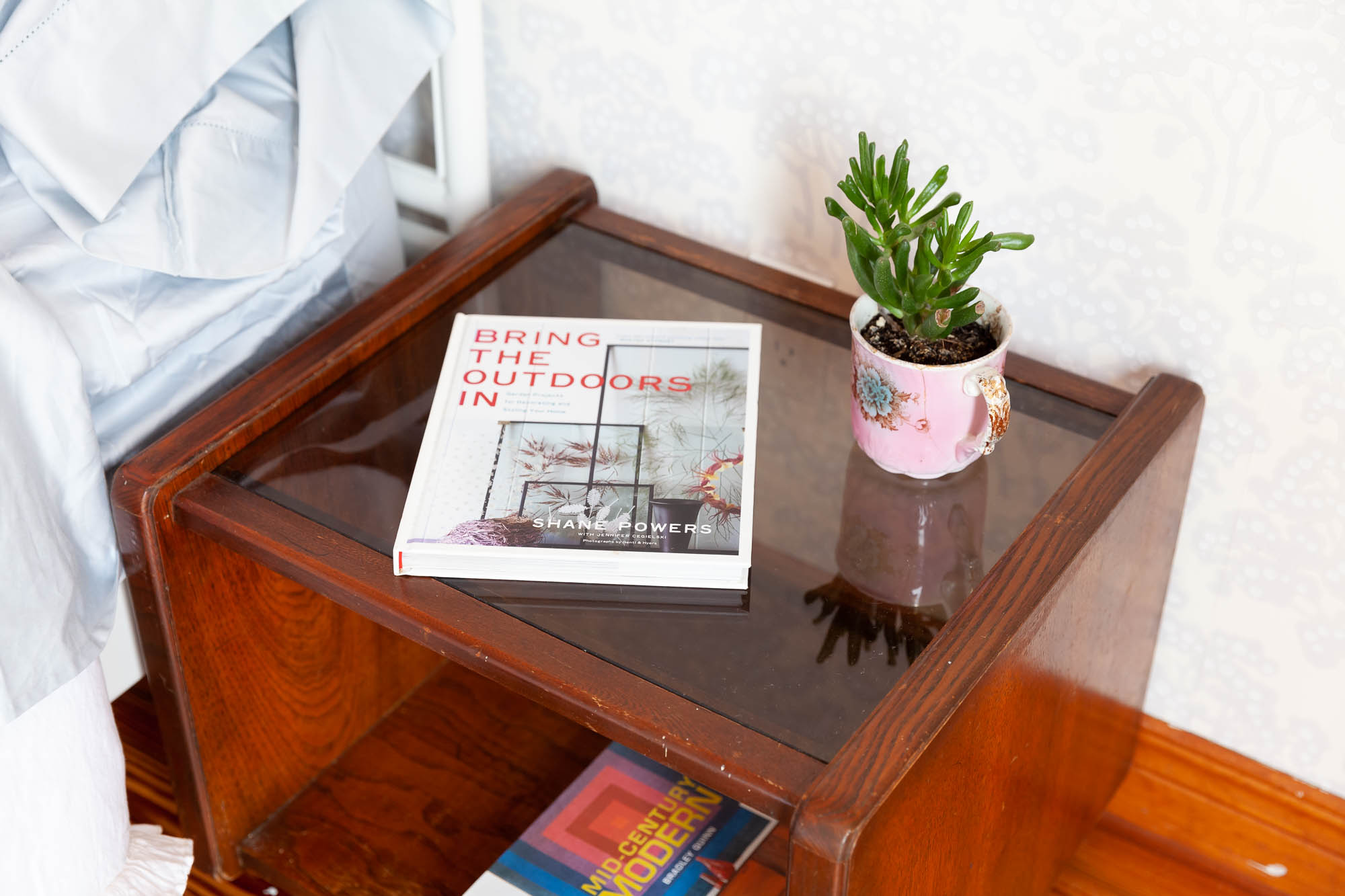 bedside table with book and plant in Collingwood, Ontario
