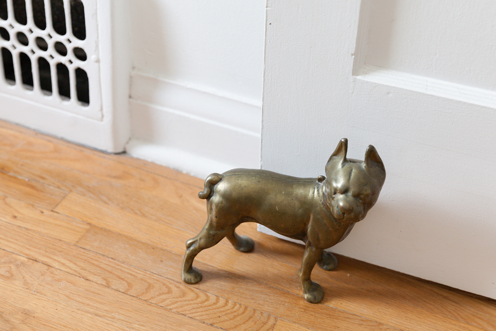 A vintage brass door stopper in the shape of a dog