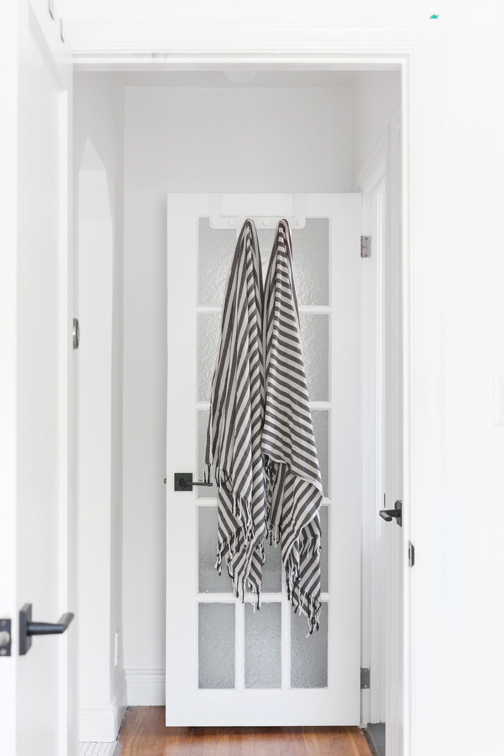 Two striped Turkish towels hanging from a hook on the bathroom door