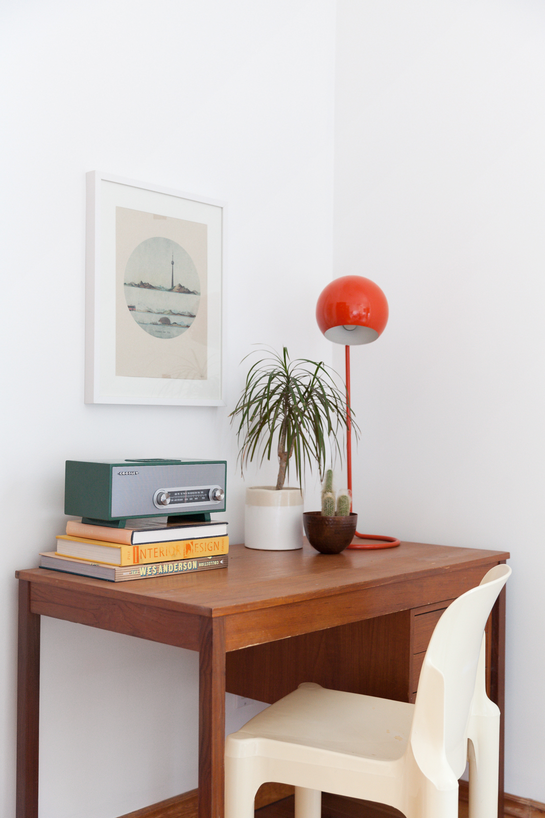 teak desk with orange reading lamp and books