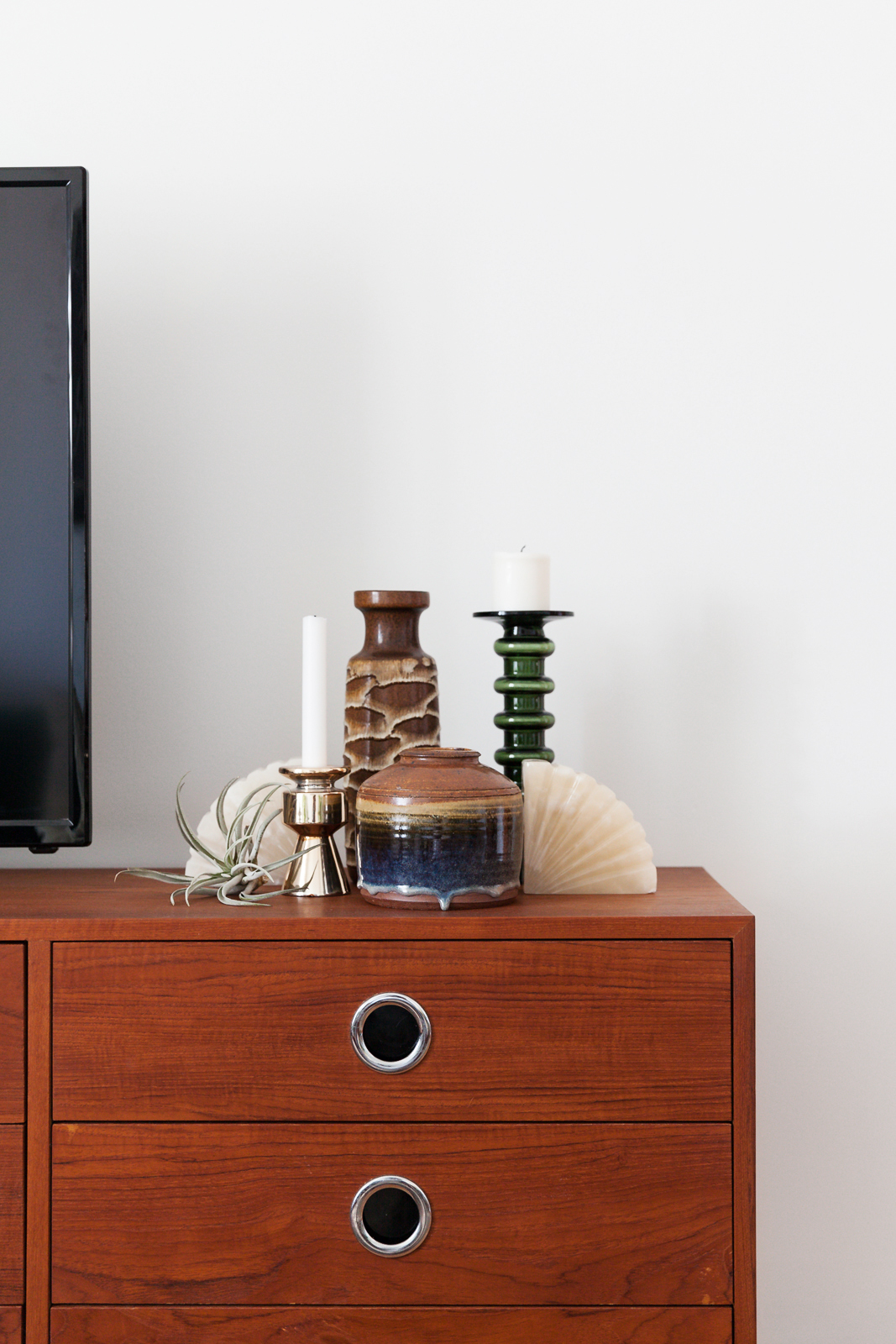 West German pottery, candles and an air plant on TV stand