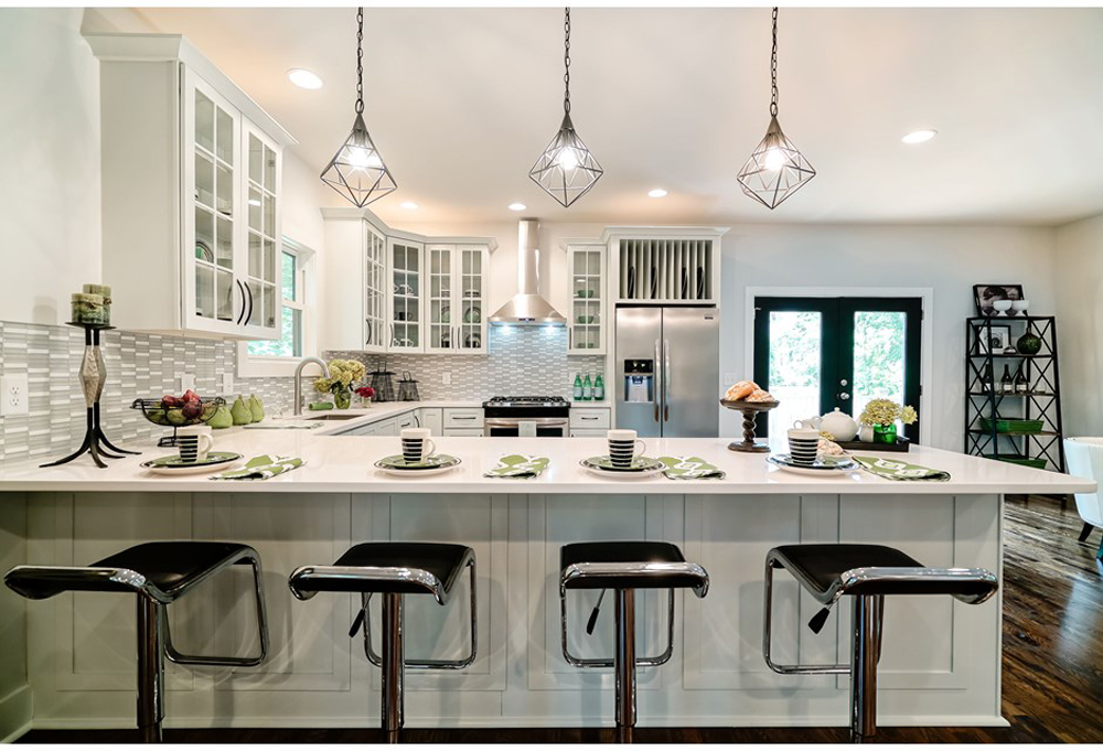 A bright white kitchen with black hardware finishes and dark trim around the doors.