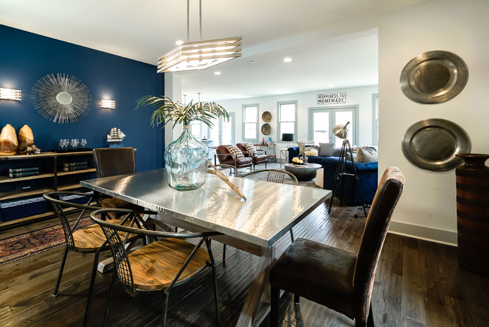 An open-concept dining room with dark blue accent wall and modern furnishings.