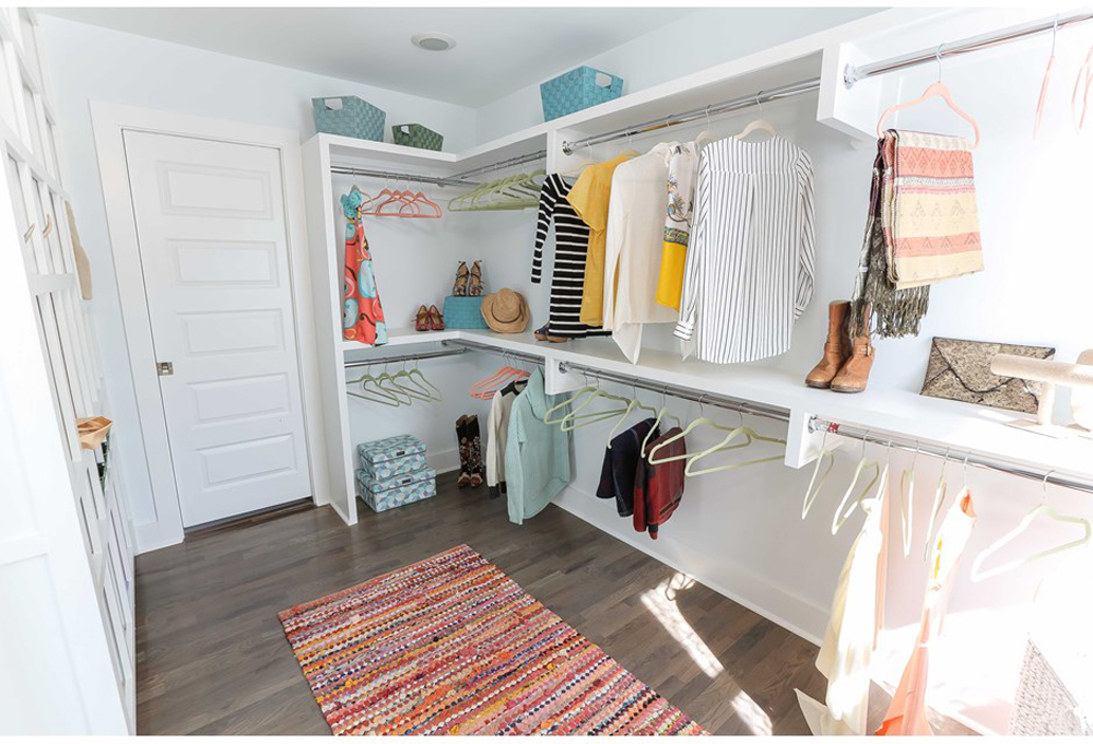 A spacious walk-in closet with a throw rug.