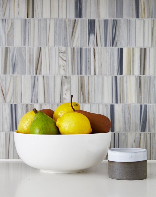 bowl of lemons and pears in front of marble backsplash
