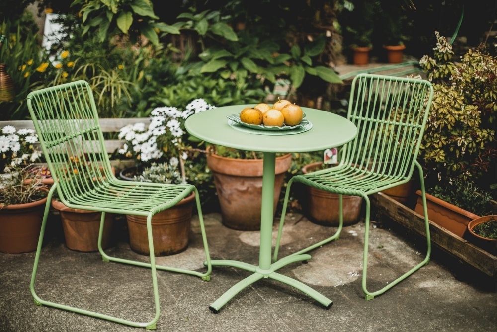 A bright green patio set with a bar table and two matching chairs.