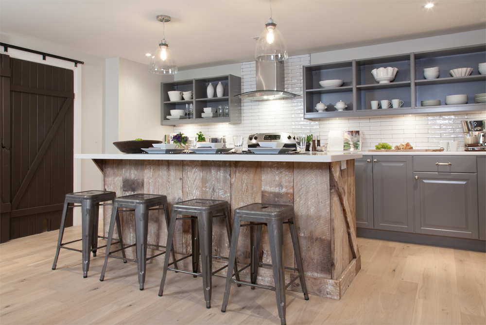 Renovated rustic kitchen with grey cabinetry and hanging light fixtures
