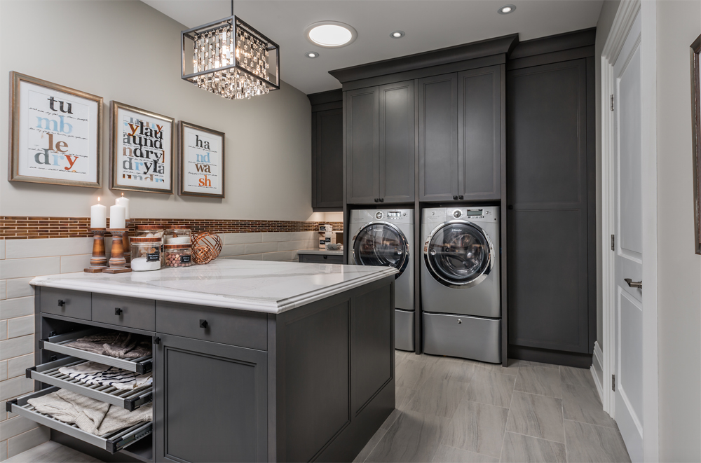 Renovated laundry room with grey cabinetry and unique light fixtures