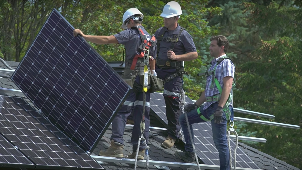 Men installing solar panels on the roof