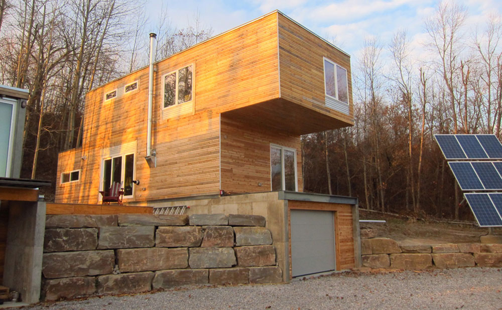 Storage container home with wood siding, including a garage
