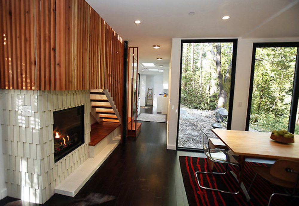 Interior of the rustic storage container home which features stairs to the second level and fireplace