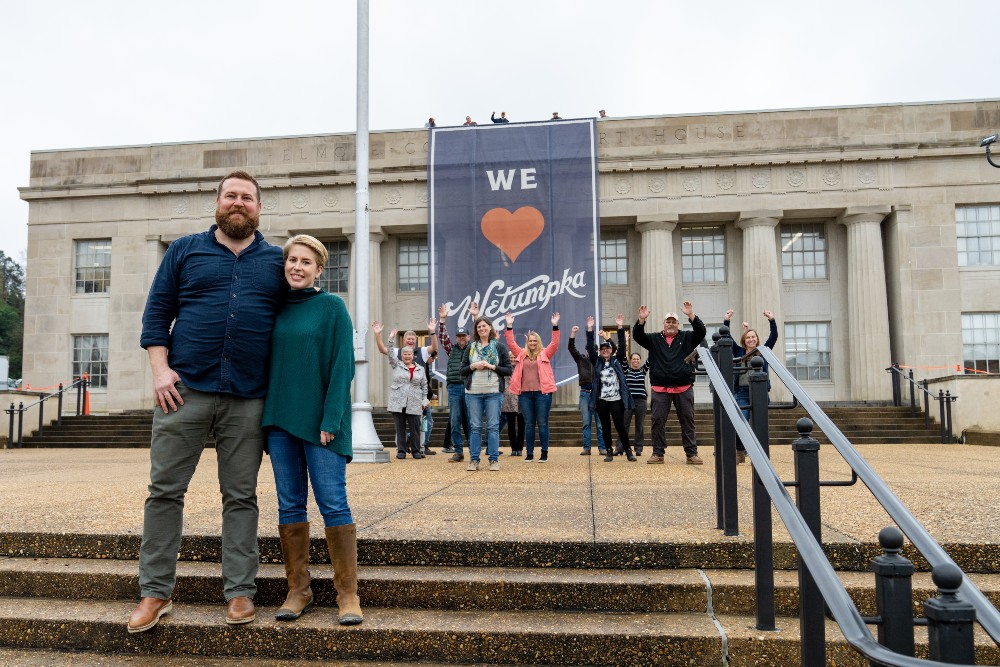 Ben and Erin Napier in front of I Love Wetumpka sign