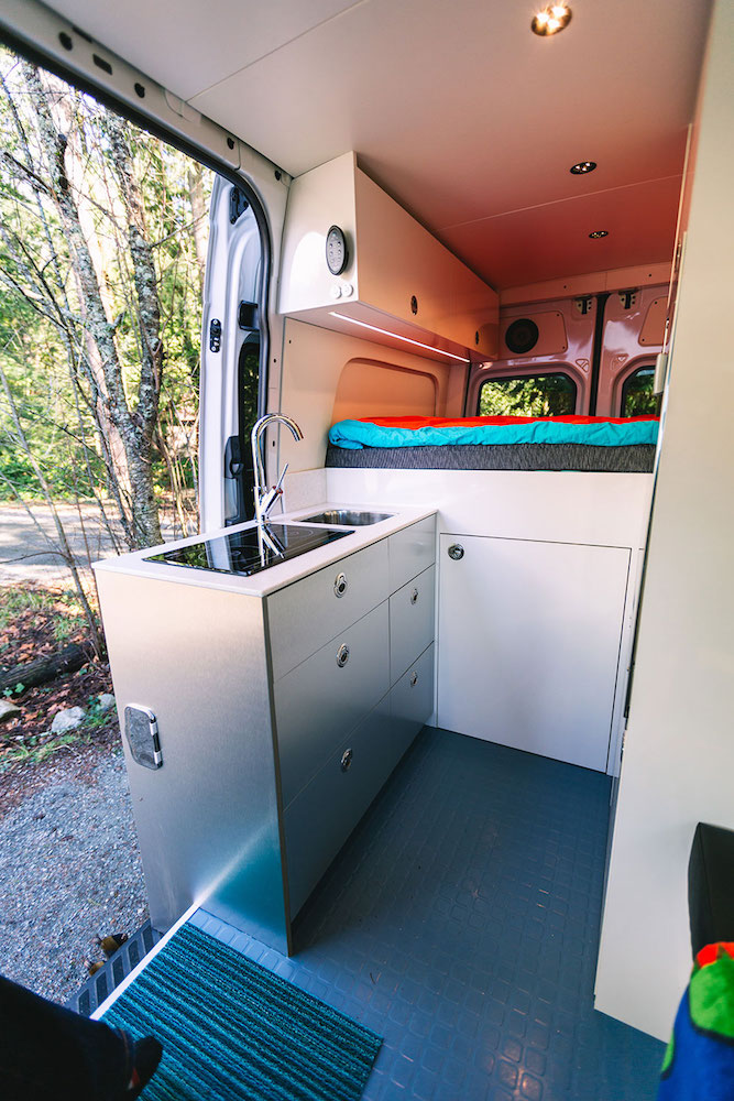 white camper van with kitchenette at open door