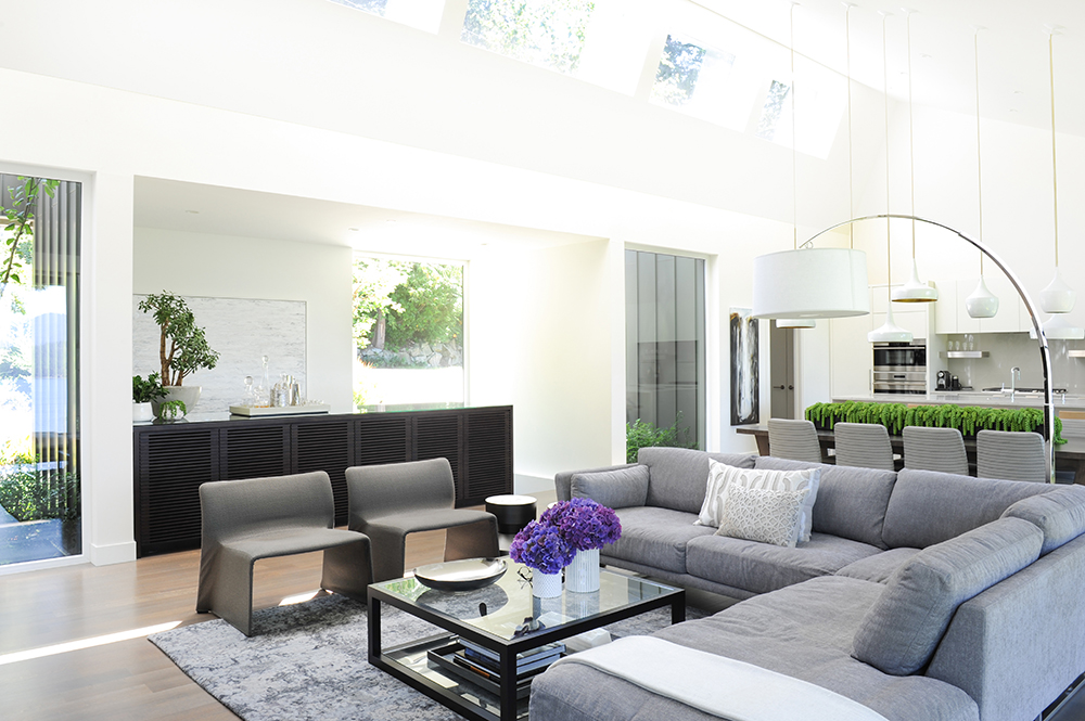 Modern grey open-concept living room with large sectional and sculptural accent chairs.
