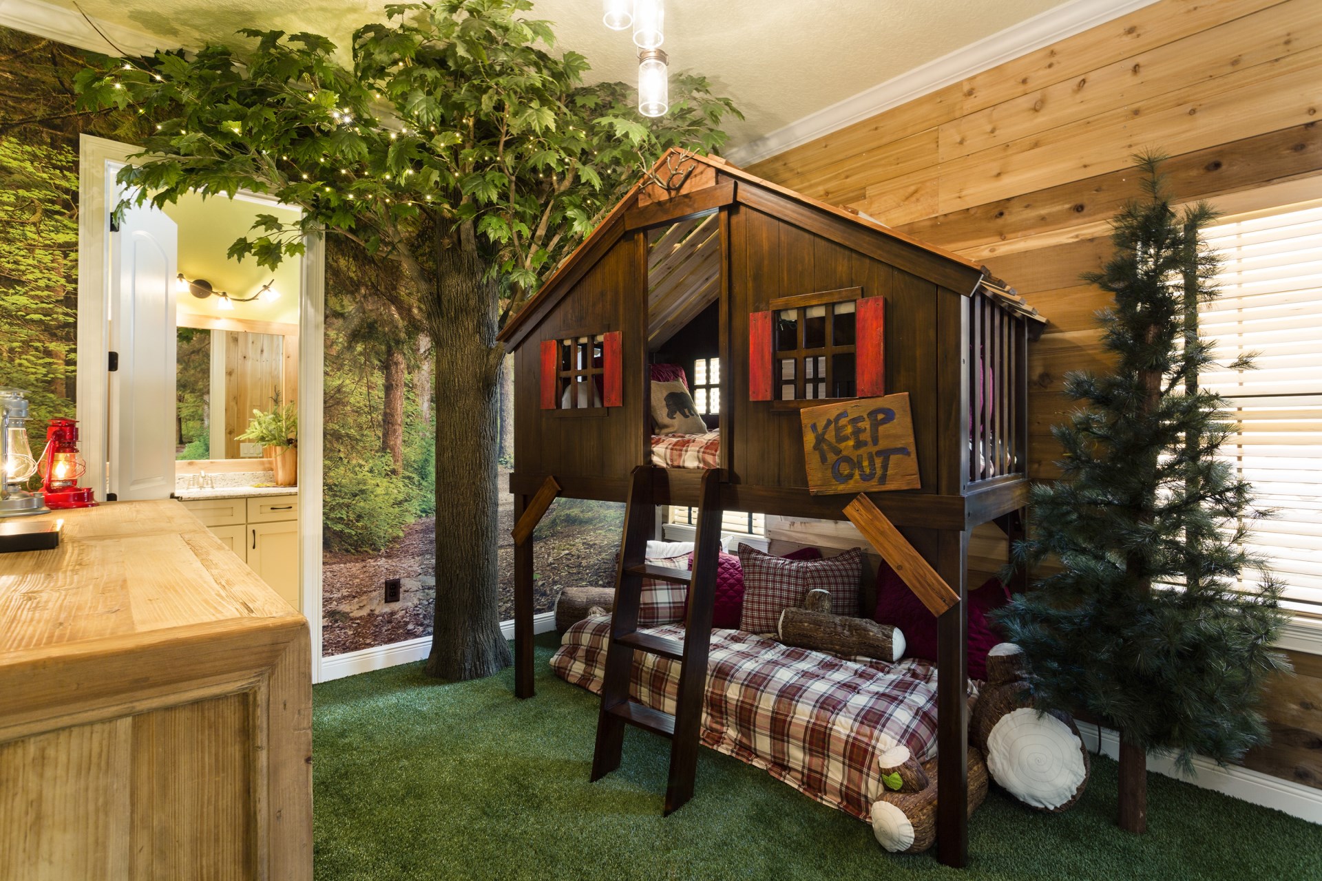 A treehouse theme with bunk beds and fake grass in the kids' bedrooms