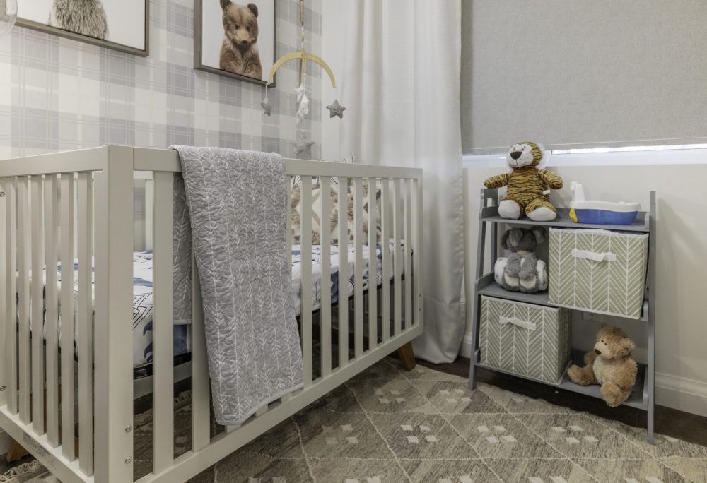 neutral-toned nursery with crib and animal pictures on wall