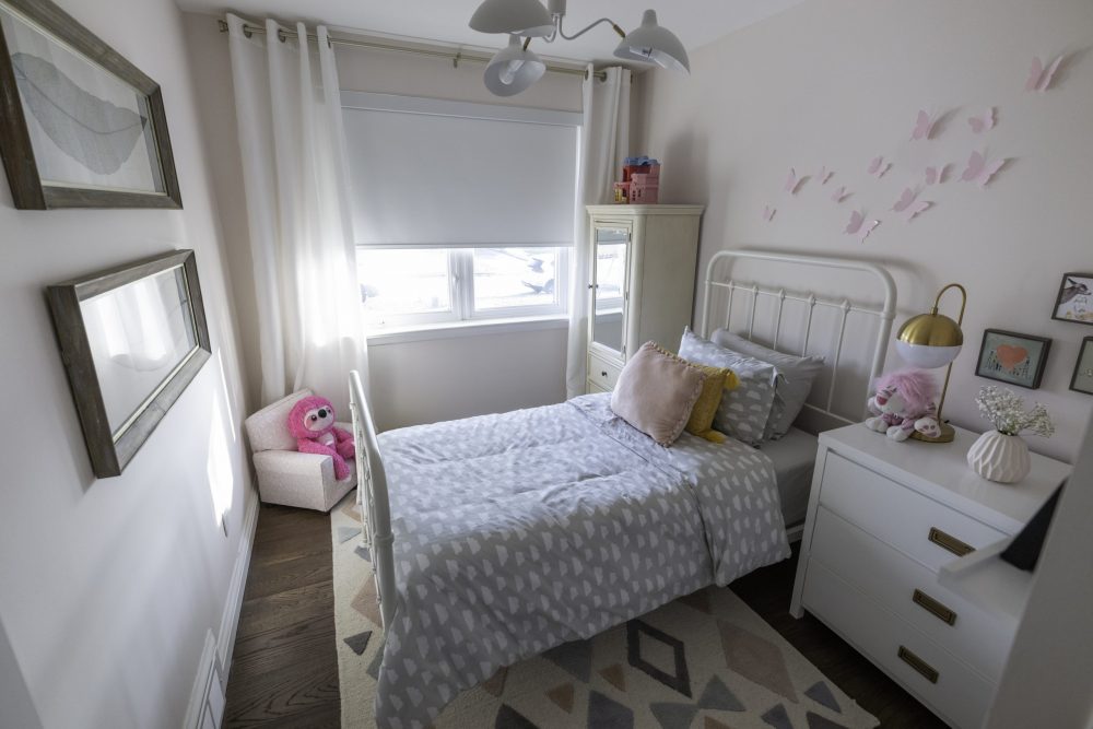 pink girls bedroom with butterflies on wall and patterned bed