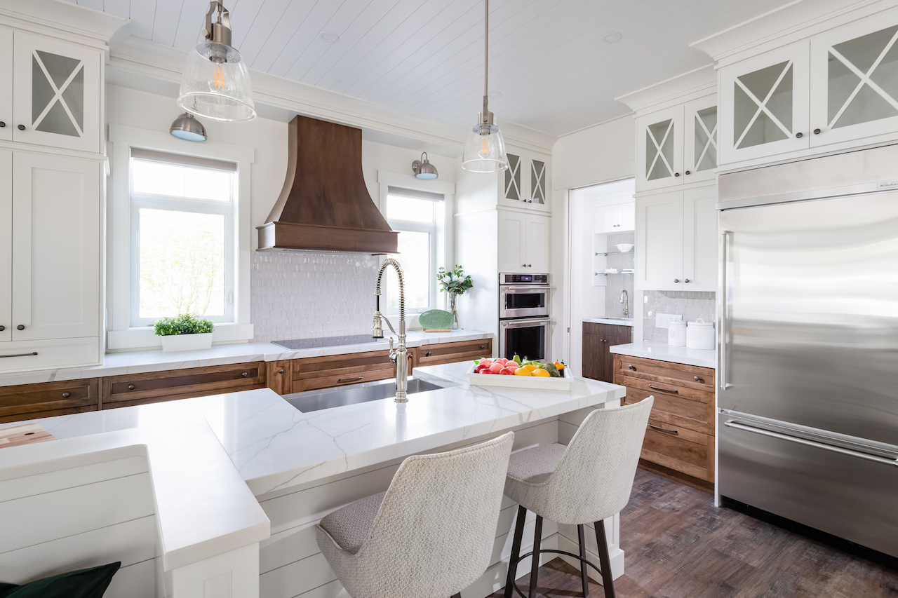 Bar-style seating at the large centre island in the kitchen is topped with off-white Corian quartz countertops
