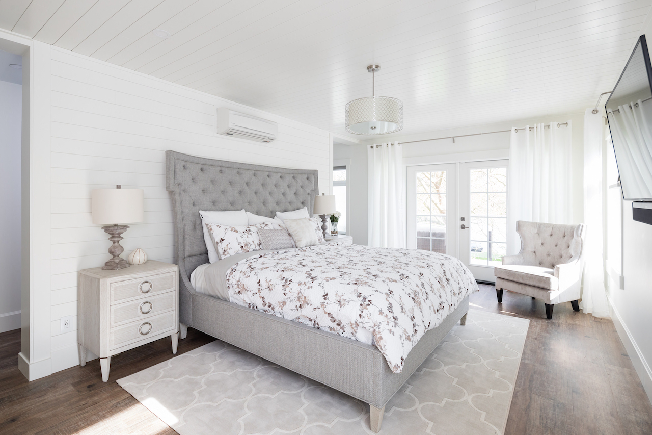 A king-sized bed with upholstered headboard is at the centre of the expansive master bedroom
