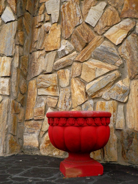 Red-painted planter on front porch of house
