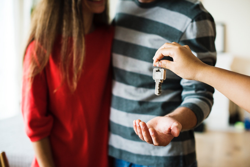woman in red shirt and man in striped shirt get keys