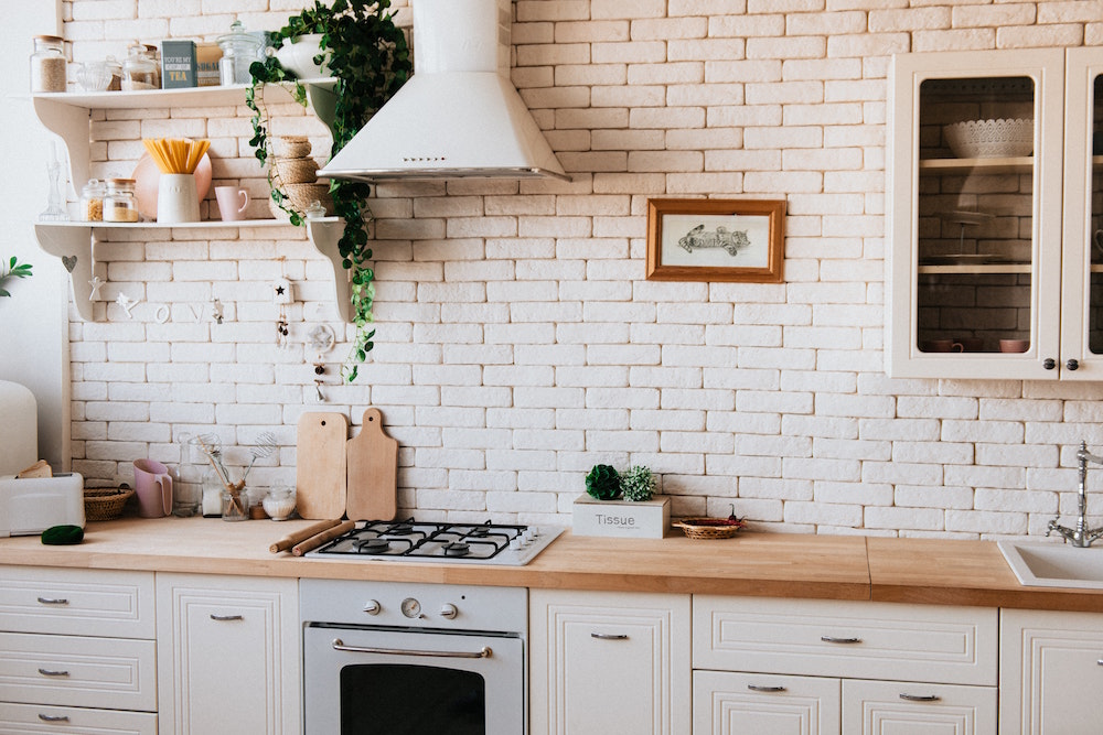 white kitchen with brick backsplash and open shelves