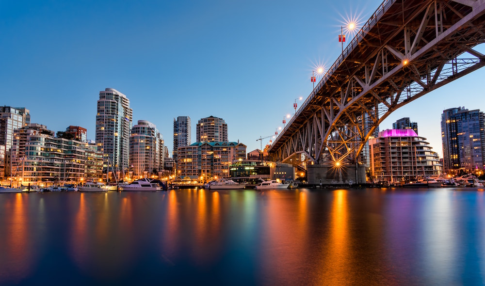 orange and blue vancouver skyline with bridge and water