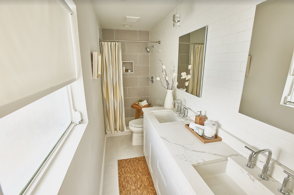 White bathroom with marble countertops and subway tile