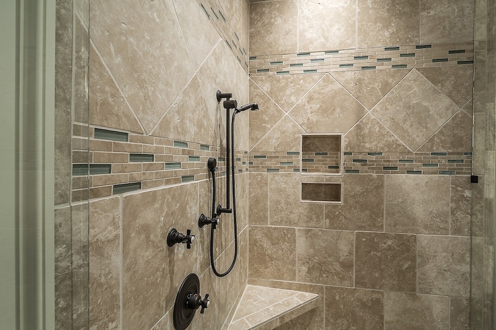 matte black shower pipes in a beige tiled shower