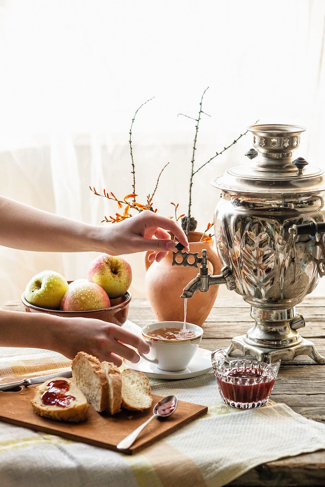 silver samovar, bread, jam and apples on wooden table
