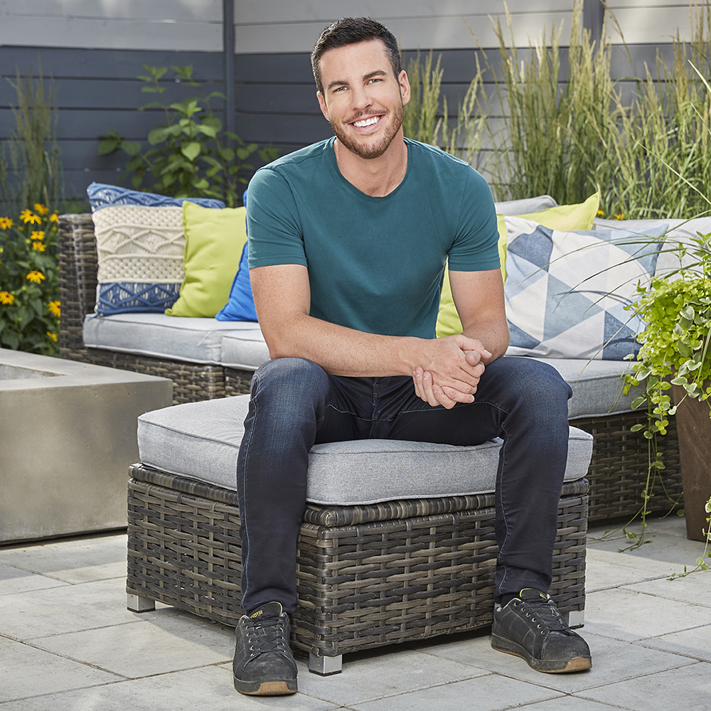 Brian McCourt sits on a set of outdoor furniture