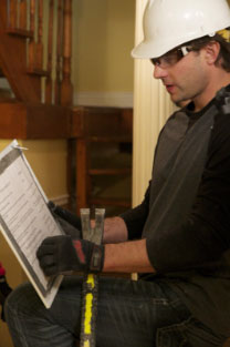 Scott McGillivray wearing a hard hat and carrying tools