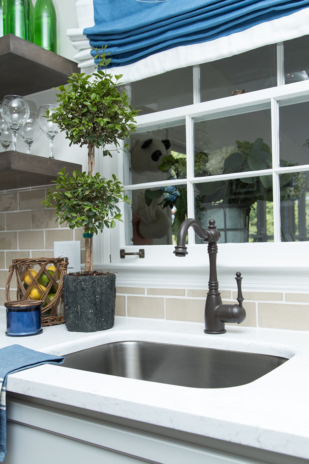 Kitchen sink with topiary and jar of lemons and limes