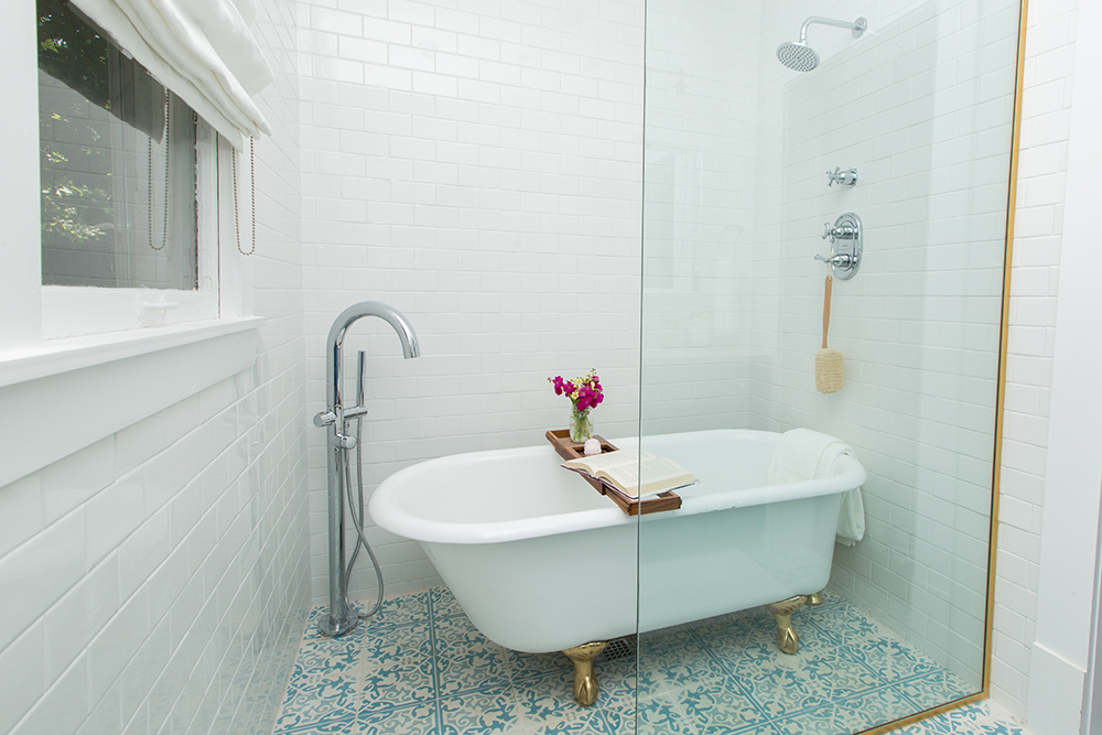 Standing tub behind glass wall with blue and white tile