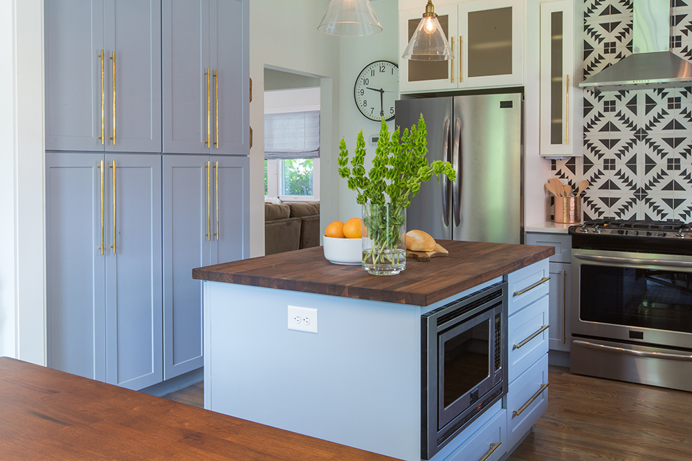 A blue kitchen with mixed hardware and finishes