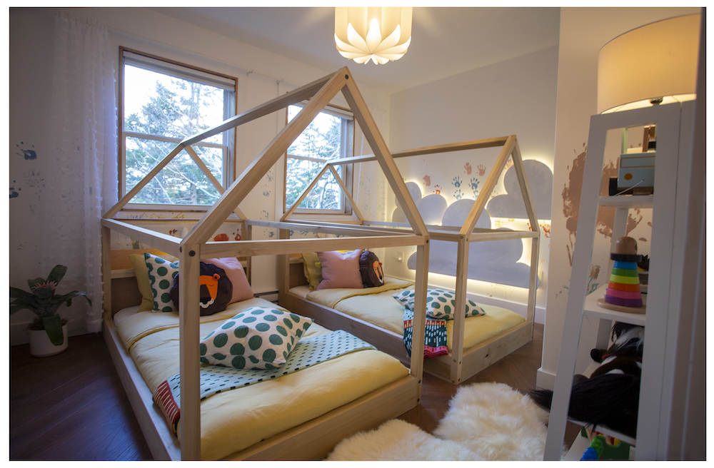 white kids room with cloud wall lights and two wood-frame beds