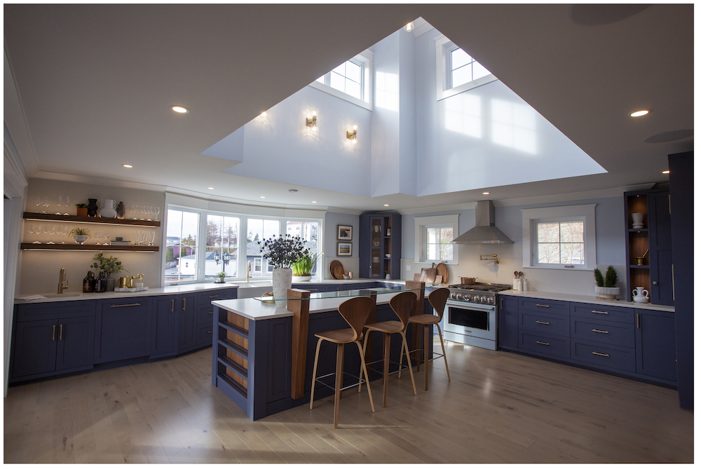 spacious white kitchen with vaulted ceiling and navy cabinets