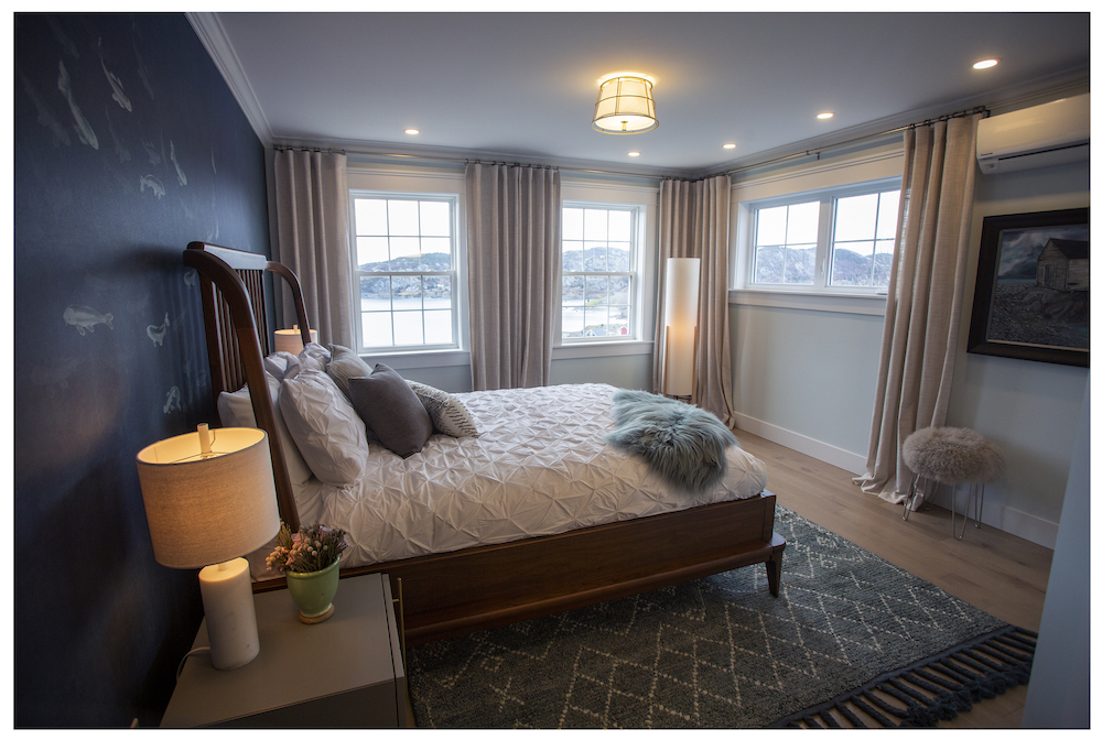 coastal bedroom with ocean mural and white bed