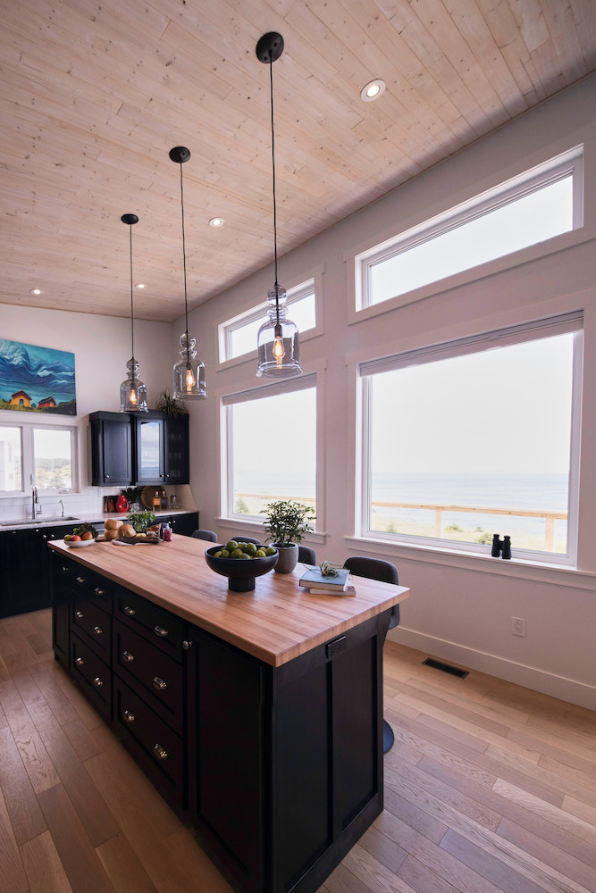 kitchen with wood-topped centre island and windows with views of the ocean