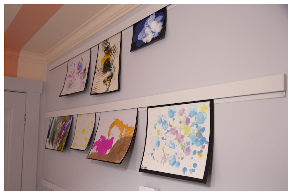 kids' art hanging on the wall in colourful craft room