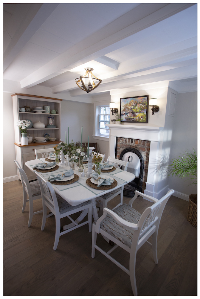 white dining room with brick fireplace beside white table and chairs