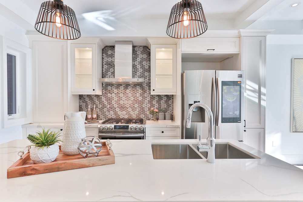 White kitchen with marble countertops and stainless steel appliances