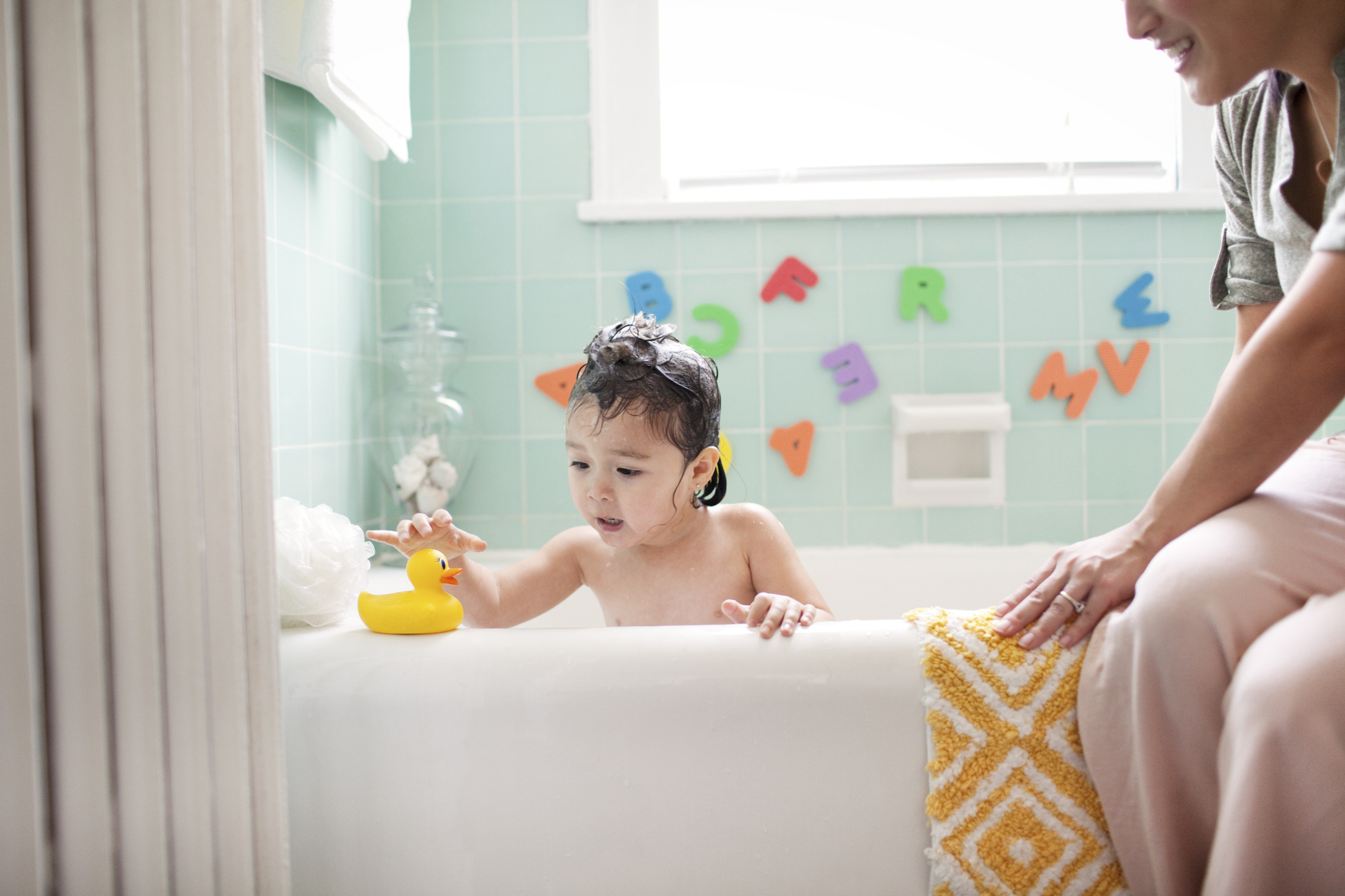 Toddler in bathtub with rubber ducky